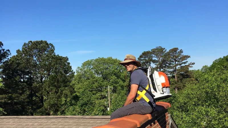 Gutter technician working safely on a residential roof