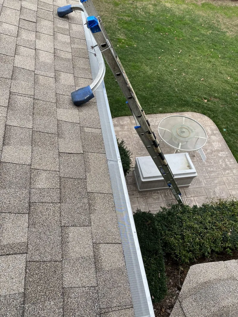 Clean white gutter beside a shingle roof